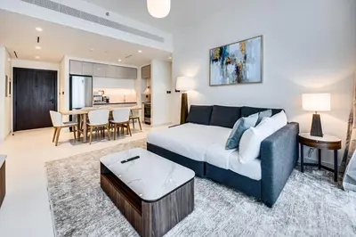 a living room with a bed and a dining room at Marvelous 1BD Sea View Apartment with Beach Access in Dubai