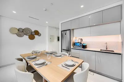 a dining room with a table and chairs and a kitchen at Marvelous 1BD Sea View Apartment with Beach Access in Dubai