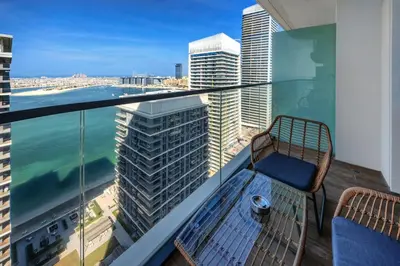 a balcony with a chair and a view of the ocean at Marvelous 1BD Sea View Apartment with Beach Access in Dubai