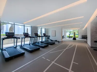 a gym with rows of treadmills in a building at Marvelous 1BD Sea View Apartment with Beach Access in Dubai