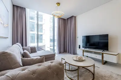 a living room with a couch and a tv at District One I MBR I Spacious and Cozy in Dubai