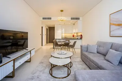 a living room with a couch and a table at District One I MBR I Spacious and Cozy in Dubai