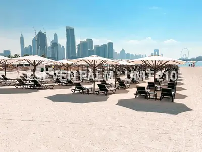 a group of chairs and umbrellas on a beach at Luxus-Studio mit Private Beach in Top-Lage, Meerblick & Infinity Pool! in Dubai