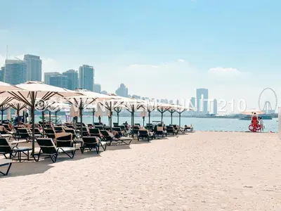 a row of chairs and umbrellas on a beach at Luxus-Studio mit Private Beach in Top-Lage, Meerblick & Infinity Pool! in Dubai