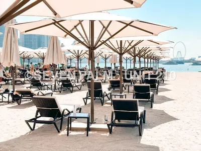 a group of chairs and umbrellas on a beach at Luxus-Studio mit Private Beach in Top-Lage, Meerblick & Infinity Pool! in Dubai