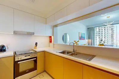 a kitchen with a sink and a stove and a window at Locations I Creek Harbor I Premium Modern 2BR I Luxury Interiors & Comfortable Stay I Close to Dubai Canal, Dining & Shopping I Pool, Gym & Parking in Dubai