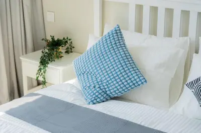 a bed with a blue and white pillow on it at Elite Escape Holiday Home - 2 BHK Getaway with Burj Khalifa View and Dubai Mall Access - 1504 in Dubai