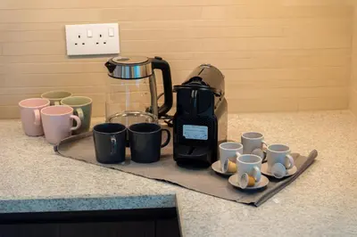 a bunch of coffee cups sitting on a counter at Elite Escape Holiday Home - 2 BHK Getaway with Burj Khalifa View and Dubai Mall Access - 1504 in Dubai