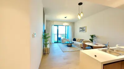 a kitchen and living room with a couch and a table at Brand New 2BR in La Rive with SeaView, Pool & Gym in Dubai