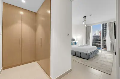 a bedroom with a bed and a large window at 2 BR in Forte, Close to Dubai Mall with Pool and Gym in Dubai