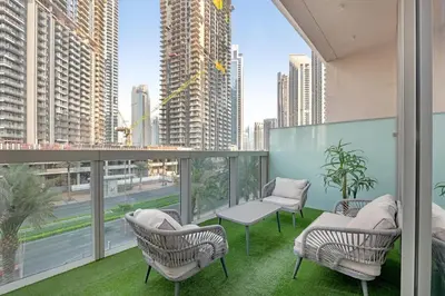 a balcony with chairs and tables and a view of a city at 2 BR in Forte, Close to Dubai Mall with Pool and Gym in Dubai