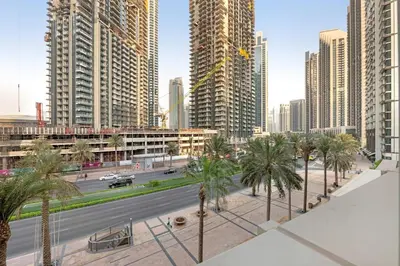 a city street with palm trees and tall buildings at 2 BR in Forte, Close to Dubai Mall with Pool and Gym in Dubai