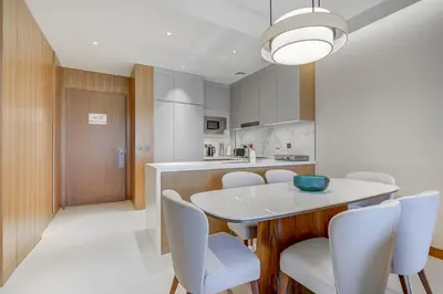 a kitchen and dining room with a white table and chairs at #25 High end 2BR in The Address Dubai Opera in Dubai