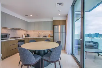 a kitchen with a round table and chairs in a kitchen at Luxe Living in Beachfront 2 Bedroom in Dubai Marina in Dubai