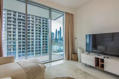 a living room with a large window and a television at Luxe Living in Beachfront 2 Bedroom in Dubai Marina in Dubai