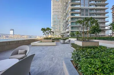 a patio with chairs and tables and a tall building at Luxe Living in Beachfront 2 Bedroom in Dubai Marina in Dubai