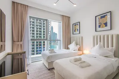 a hotel room with two beds and a large window at Luxe Living in Beachfront 2 Bedroom in Dubai Marina in Dubai