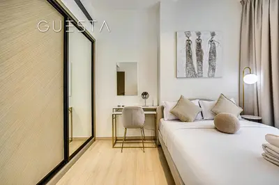 a hotel room with a bed and a desk at Binghatti Crescent, Jumeirah Village Circle in Dubai