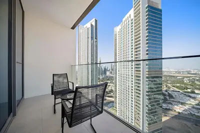 a balcony with two chairs and a view of a city at Silkhaus Heart of Downtown High Floor with View in Dubai