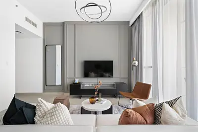 a living room with a white couch and a tv at Silkhaus Heart of Downtown High Floor with View in Dubai