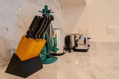 a group of knives in a knife block on a counter at Peaceful 2BR Retreat Near Burj Al Arab in Dubai