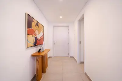 a hallway with white walls and a painting on the wall at Peaceful 2BR Retreat Near Burj Al Arab in Dubai