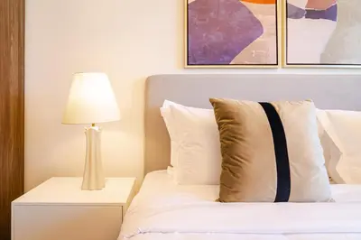 a bedroom with a bed with a lamp on a night stand at Peaceful 2BR Retreat Near Burj Al Arab in Dubai
