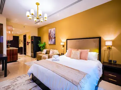 a large bedroom with a large bed and a couch at Cozy Studio with Burj Khalifa Views in Dubai