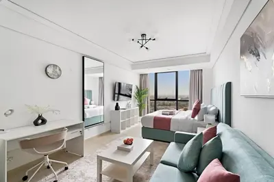 a bedroom with a bed and a couch and a desk at StoneTree - Cozy Studio - JLT in Dubai