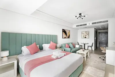 a bedroom with a large bed and a living room at StoneTree - Cozy Studio - JLT in Dubai