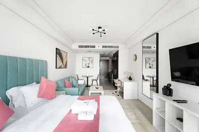 a living room with a couch and a tv at StoneTree - Cozy Studio - JLT in Dubai