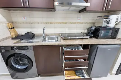 a kitchen with a sink and a washing machine at StoneTree - Cozy Studio - JLT in Dubai