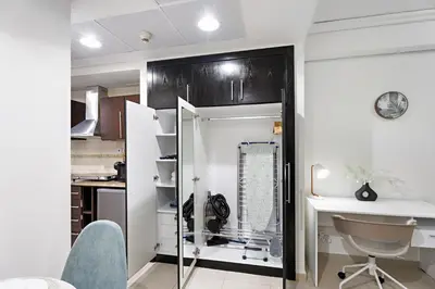 a kitchen with a glass shower and a desk at StoneTree - Cozy Studio - JLT in Dubai