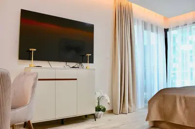 a bedroom with a white dresser with a television on it at Розкішна квартира з видом на Бурж Халіфа in Dubai