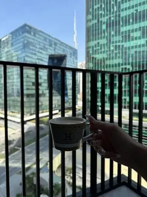 a person holding a metal object on a balcony at Розкішна квартира з видом на Бурж Халіфа in Dubai
