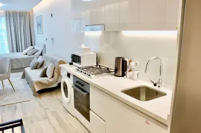 a white kitchen with a sink and a microwave at Розкішна квартира з видом на Бурж Халіфа in Dubai