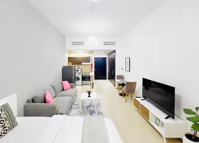 a living room with a couch and a tv at Studio Apartment in Dubai Marina with Balcony in Dubai