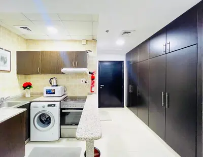 a kitchen with a washing machine and a washer at Studio Apartment in Dubai Marina with Balcony in Dubai