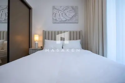a bedroom with a large white bed and a mirror at Stylish 1br Business Bay W Burj Views in Dubai