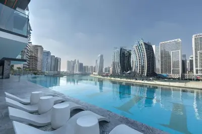 a large swimming pool in a city with tall buildings at Stylish 1br Business Bay W Burj Views in Dubai