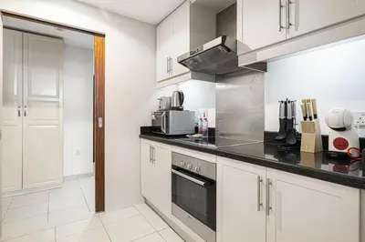 a kitchen with white cabinets and black counter tops at Classic 1 Bed Suite in The Residence Tower 3 in Dubai