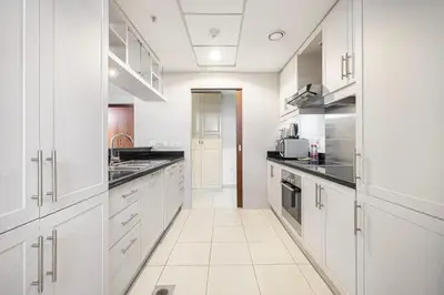 a white kitchen with white cabinets and appliances at Classic 1 Bed Suite in The Residence Tower 3 in Dubai