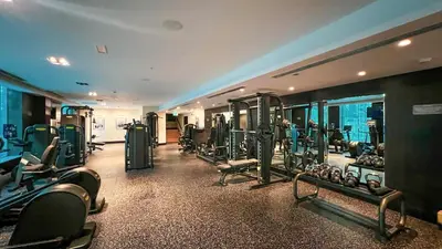 a gym with rows of exercise equipment in a building at Classic 1 Bed Suite in The Residence Tower 3 in Dubai