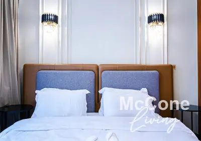 a bedroom with a bed with two blue chairs at Classic 1 Bed Suite in Burj Vista Tower, Downtown in Dubai