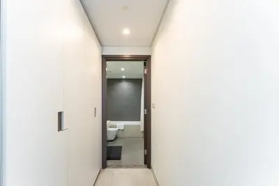 a hallway with white walls and a door to a bathroom at Stylish 1BR in Wasl 1 with Balcony & Pool in Dubai