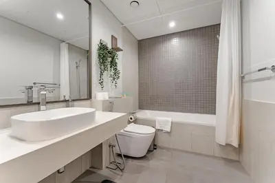 a bathroom with a sink and a toilet and a tub at Stylish 1BR in Wasl 1 with Balcony & Pool in Dubai