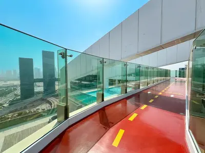 an empty balcony of a building with glass walls at Stylish 1BR in Wasl 1 with Balcony & Pool in Dubai