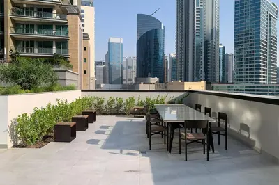 a table and chairs on a balcony with a city skyline at Frank Porter - DT1 Tower in Dubai