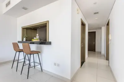 a hallway with white walls and stools in a house at Frank Porter - The Lofts West in Dubai