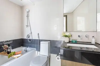 a bathroom with a toilet and a tub and a sink at Frank Porter - The Lofts West in Dubai